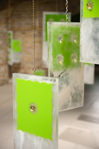 a group of green ice cubes hanging from a chain